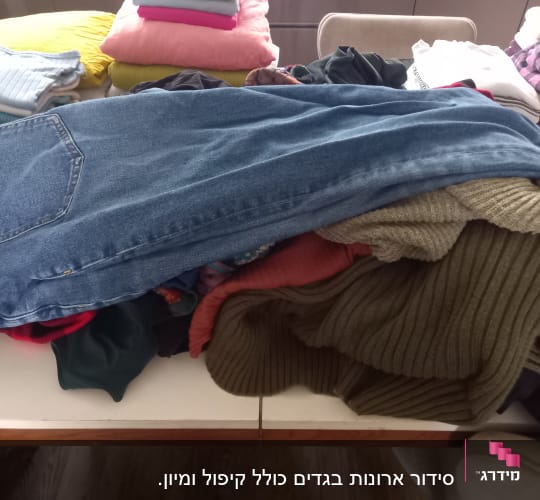 בגדים מקופלים על שולחן, כולל ג
